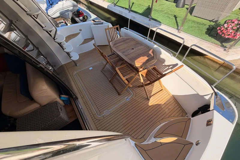 Slide: The Image of 1999 Carver 530 Voyager Pilothouse yacht deck with wooden table and chairs. - 22