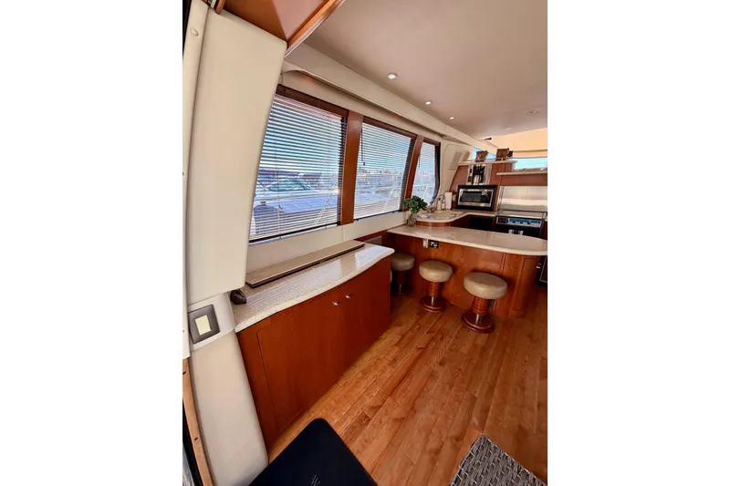 Slide: The Image of Interior of 1999 Carver 530 Voyager Pilothouse with wooden cabinetry and bar stools. - 26