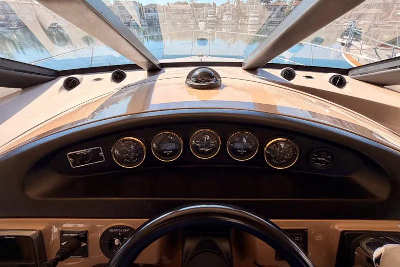 Slide: The Image of 1999 Carver 530 Voyager Pilothouse dashboard with gauges and controls, overlooking marina. - 47
