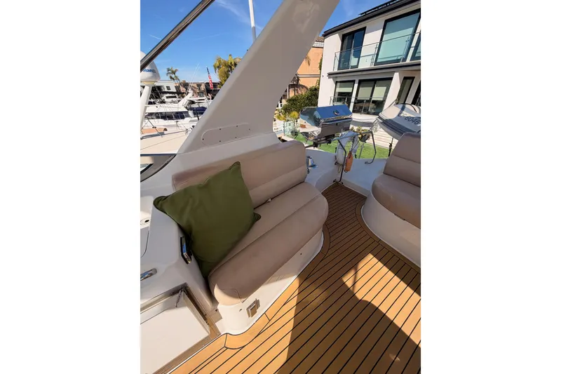 Slide: The Image of 1999 Carver 530 Voyager Pilothouse deck with cushioned seating and green pillow. - 59