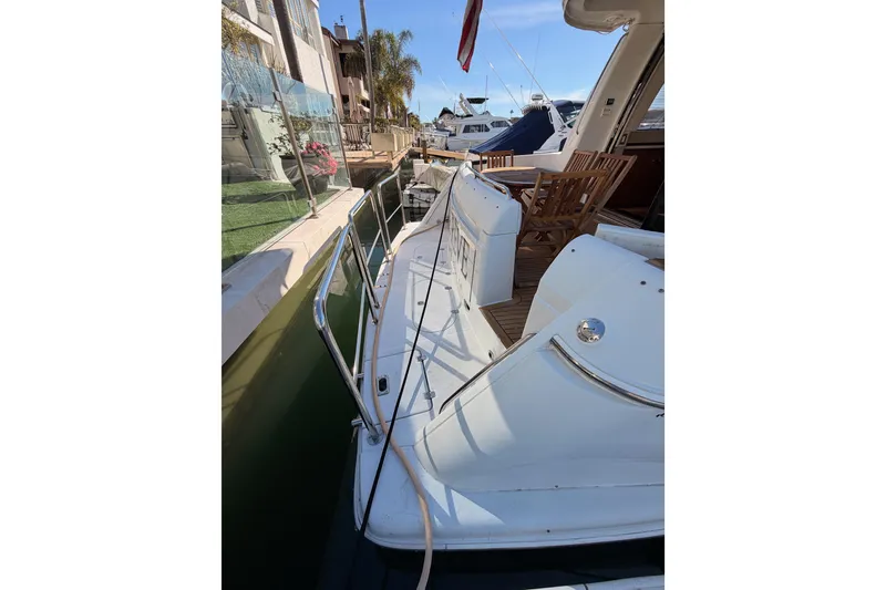 Slide: The Image of 1999 Carver 530 Voyager Pilothouse yacht docked, featuring a spacious deck and wooden chairs. - 8