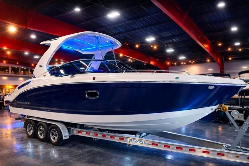 The Image of 2019 Chaparral 317 SSX boat on trailer in showroom with blue lighting. - 0