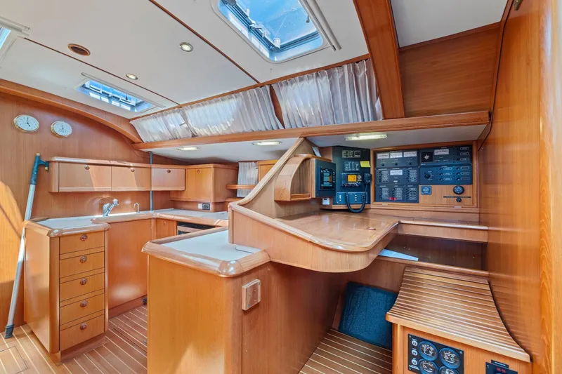Slide: The Image of Luxurious 2001 Jeanneau Sun Odyssey 52.2 yacht interior with wood finish and navigation controls. - 22