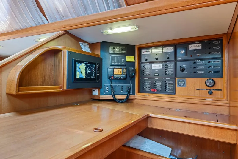 Slide: The Image of Navigation station of 2001 Jeanneau Sun Odyssey 52.2 yacht with control panels and equipment. - 24