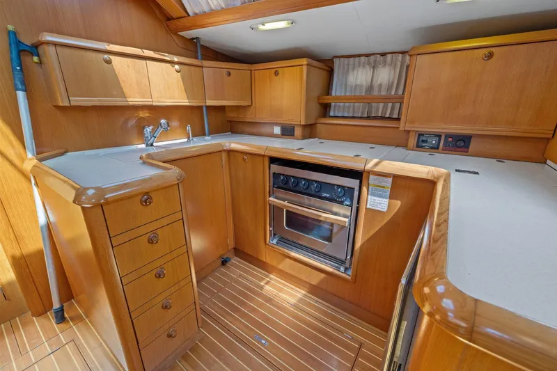 Slide: The Image of 2001 Jeanneau Sun Odyssey 52.2 yacht kitchen with wood cabinetry and modern appliances. - 25