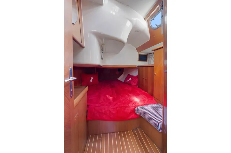Slide: The Image of Cozy cabin interior of 2001 Jeanneau Sun Odyssey 52.2 with red bedding and wooden accents. - 30