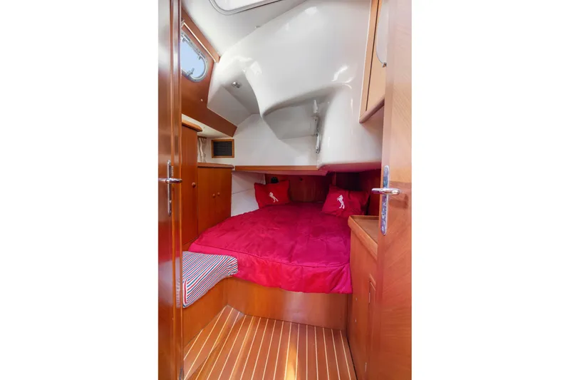 Slide: The Image of Cozy cabin interior of 2001 Jeanneau Sun Odyssey 52.2 with red bedding and wooden finish. - 31