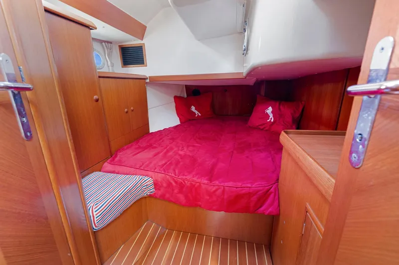 Slide: The Image of Cozy cabin interior of 2001 Jeanneau Sun Odyssey 52.2 with red bedding and wooden finish. - 32