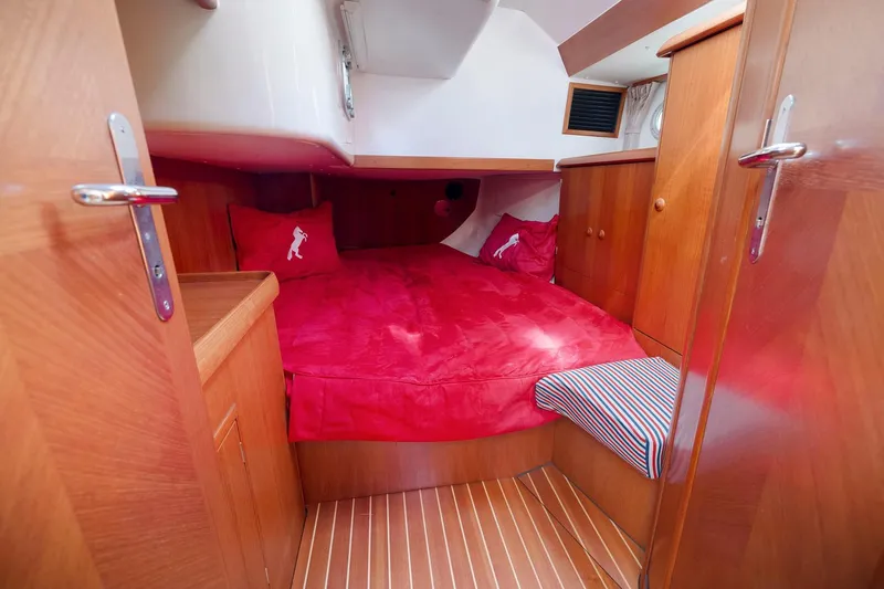 Slide: The Image of Cozy cabin interior of 2001 Jeanneau Sun Odyssey 52.2 with red bedding and wooden finish. - 33