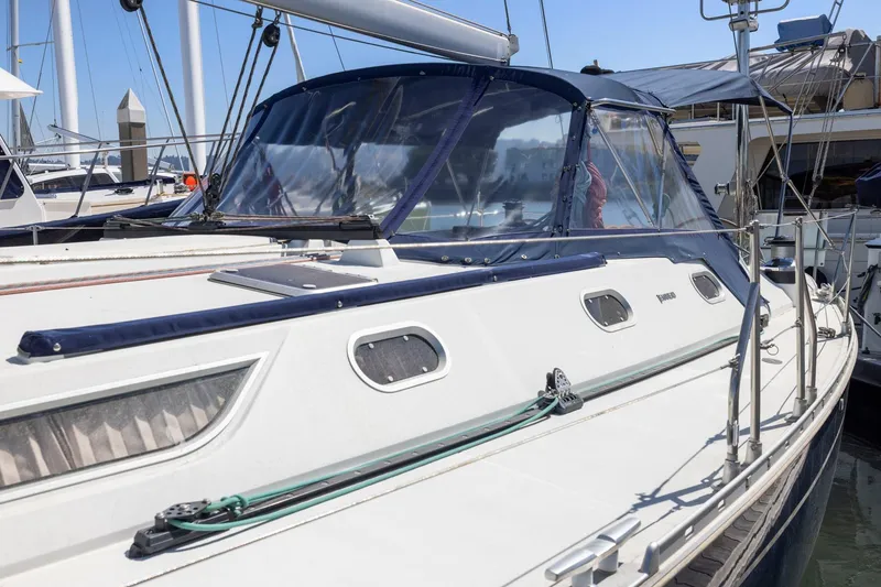 Slide: The Image of 2001 Jeanneau Sun Odyssey 52.2 sailboat docked at marina, featuring sleek design and blue canopy. - 7
