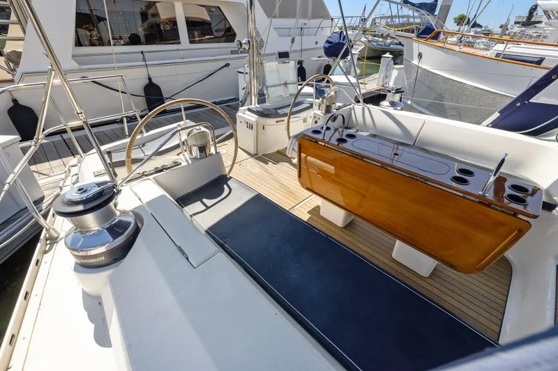Slide: The Image of 2001 Jeanneau Sun Odyssey 52.2 yacht cockpit with dual steering wheels and wooden table. - 9