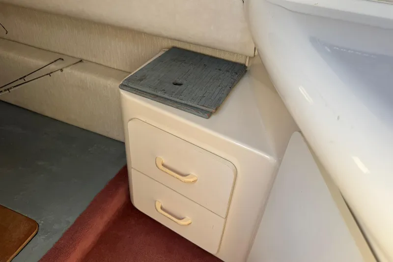 Slide: The Image of Interior of 1994 Sea Ray 270 Sundancer with storage drawers and seating area. - 13