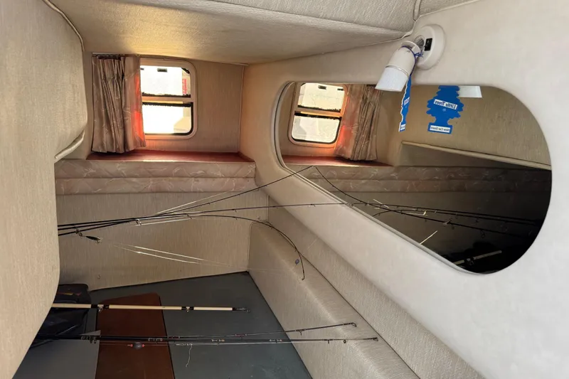 Slide: The Image of 1994 Sea Ray 270 Sundancer cabin interior with fishing rods and windows. - 14