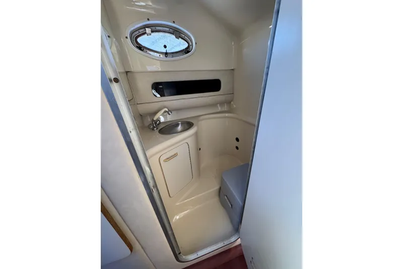 Slide: The Image of 1994 Sea Ray 270 Sundancer boat bathroom with sink and porthole window. - 18