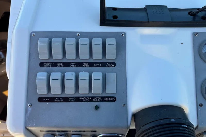 Slide: The Image of Control panel of a 1994 Sea Ray 270 Sundancer boat with labeled switches. - 21