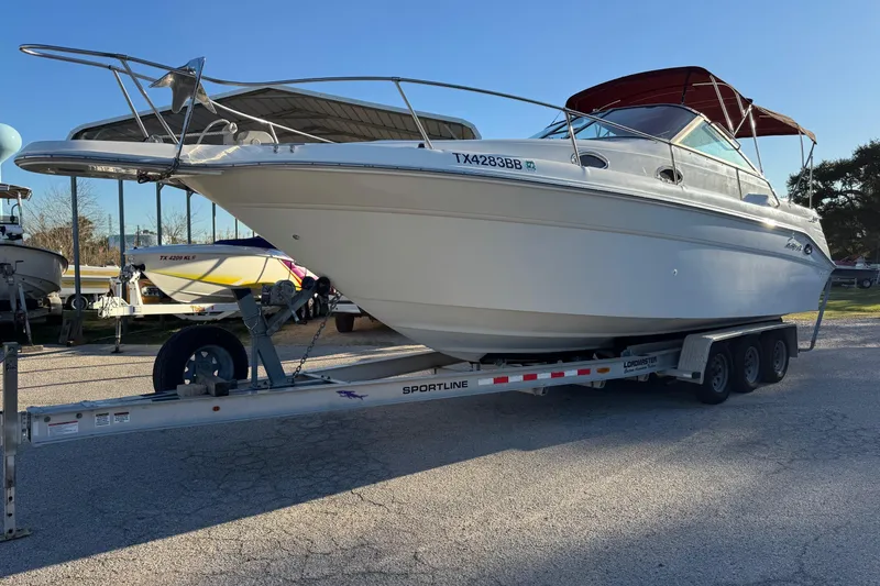 Slide: The Image of 1994 Sea Ray 270 Sundancer boat on trailer, parked outdoors. - 3
