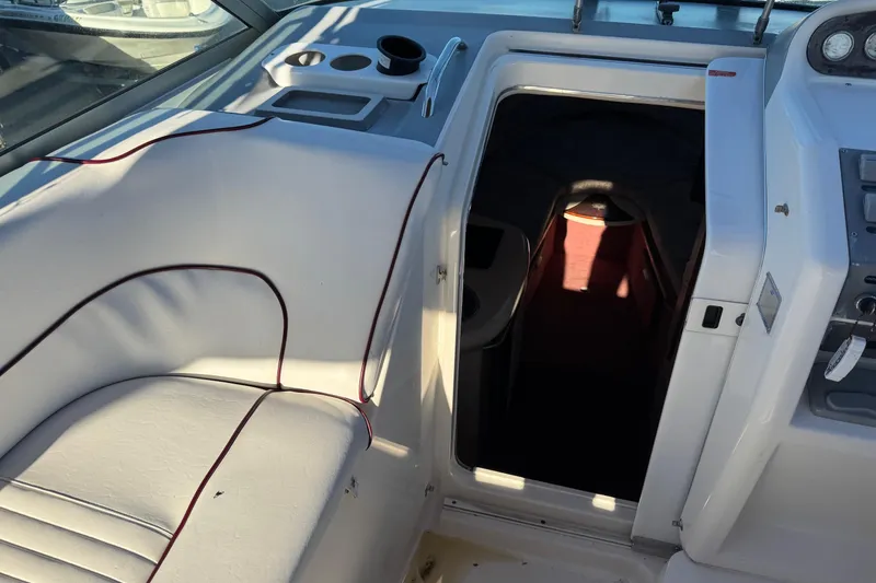 Slide: The Image of 1994 Sea Ray 270 Sundancer interior with white seating and cabin entrance. - 30