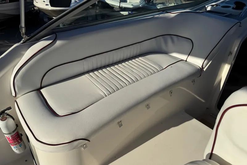 Slide: The Image of 1994 Sea Ray 270 Sundancer interior with white cushioned seating and fire extinguisher. - 32