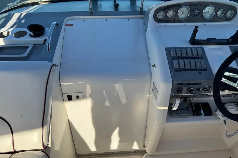Slide: The Image of 1994 Sea Ray 270 Sundancer helm with gauges, switches, and steering wheel. - 5