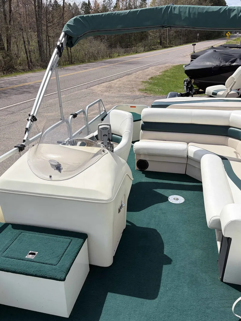 Slide: The Image of Interior of a 1999 Lowe Suncruiser 22 pontoon boat with green upholstery. - 3