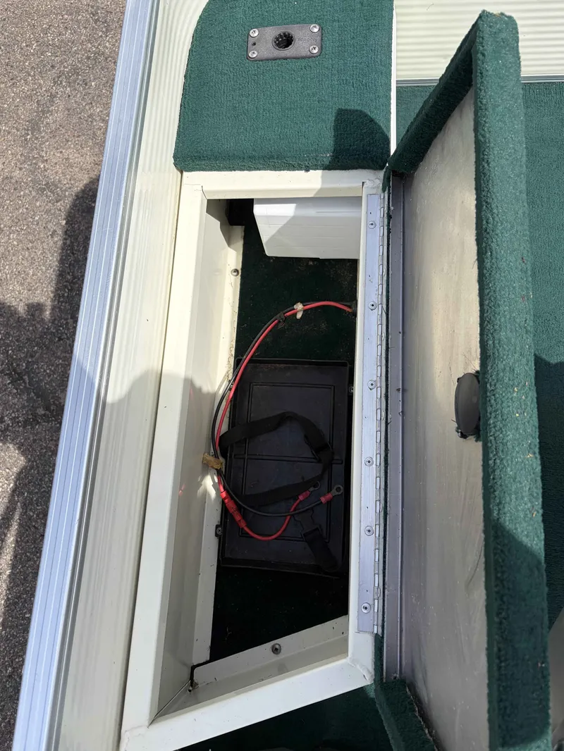 Slide: The Image of Battery compartment of a 1999 Lowe Suncruiser 22 boat with green carpet. - 6