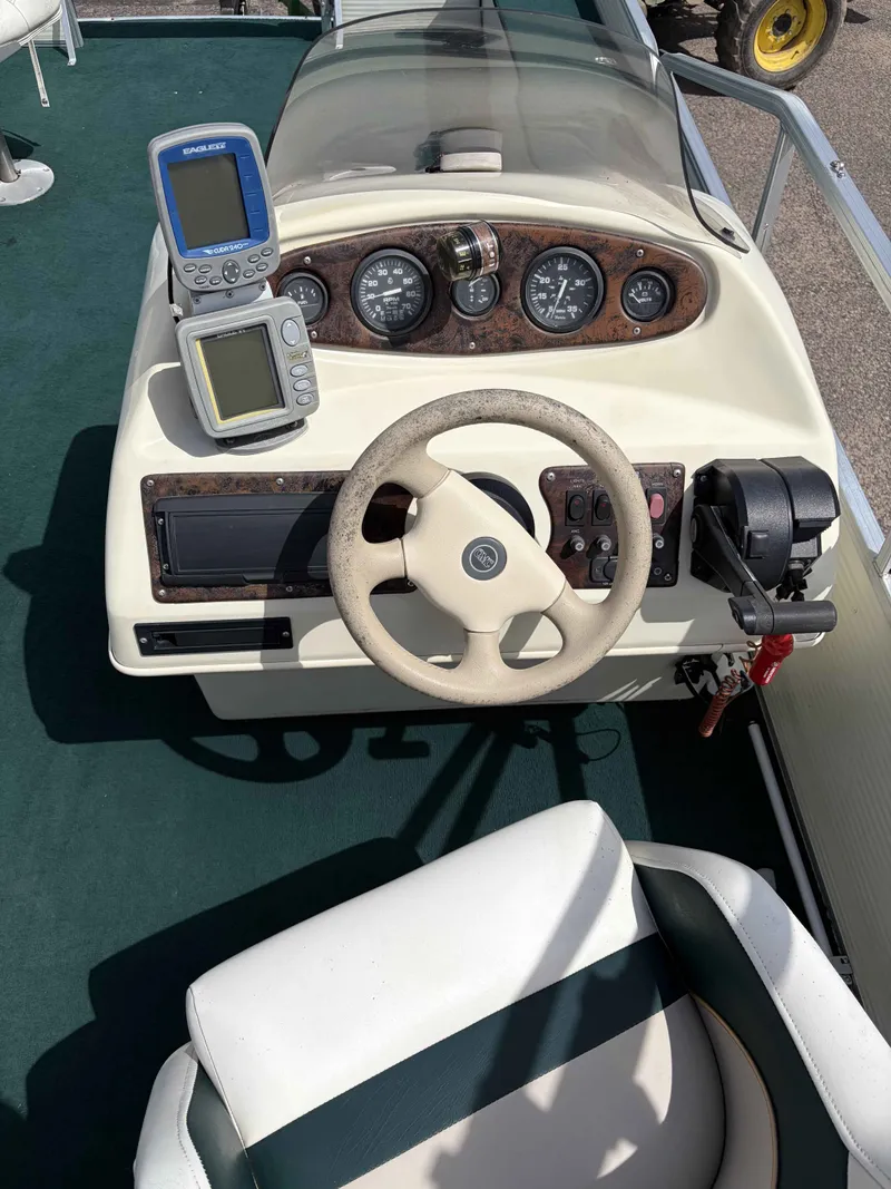 Slide: The Image of 1999 Lowe Suncruiser 22 boat console with steering wheel and instruments. - 7