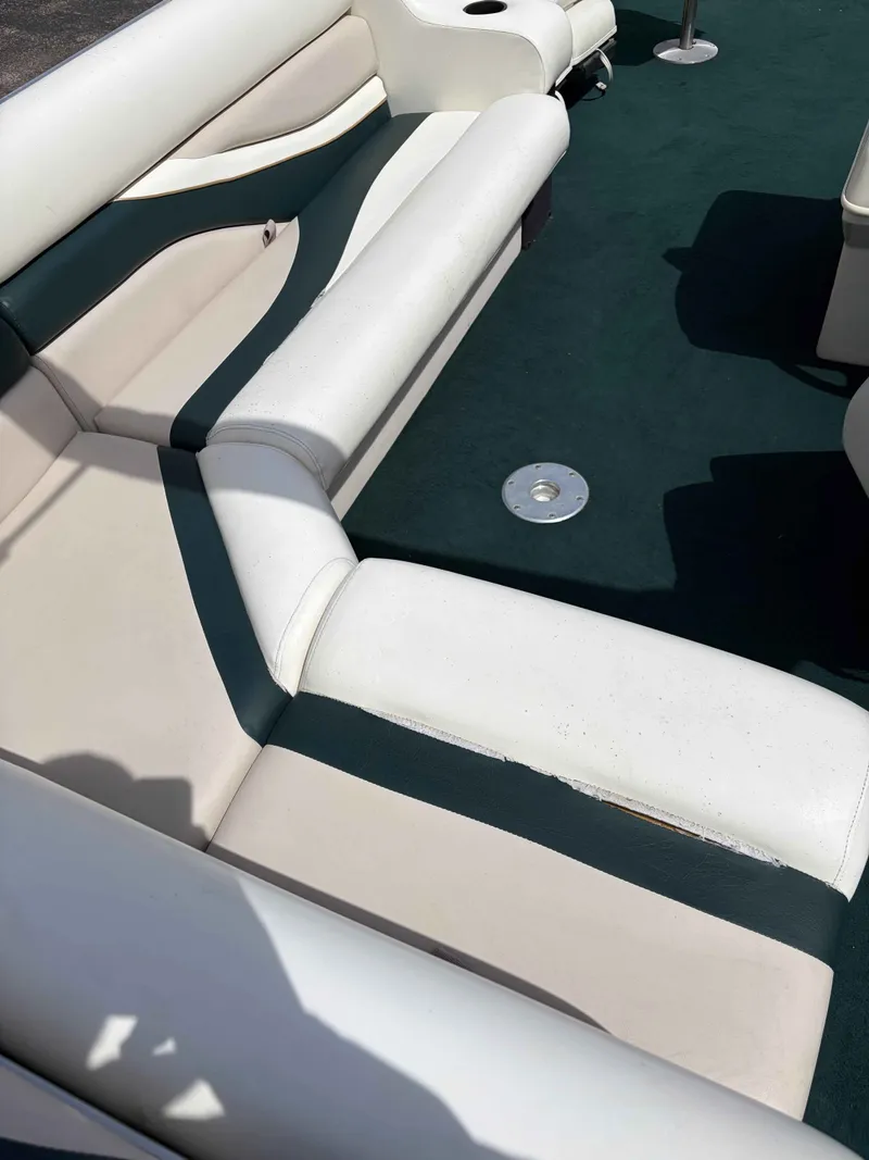 Slide: The Image of Interior of a 1999 Lowe Suncruiser 22 pontoon boat with white seating. - 8