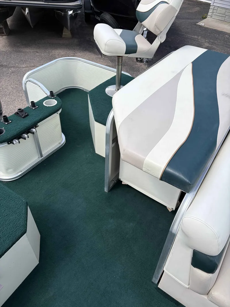 Slide: The Image of Interior of a 1999 Lowe Suncruiser 22 pontoon boat with green upholstery. - 9