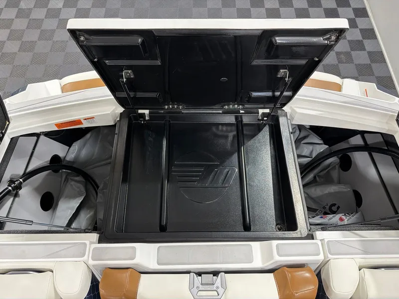 Slide: The Image of 2023 Malibu M220 boat storage compartment with open lid. - 21