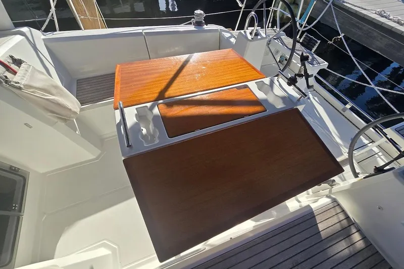 Slide: The Image of 2023 Beneteau Oceanis 38.1 cockpit with wooden table and dual steering wheels. - 17