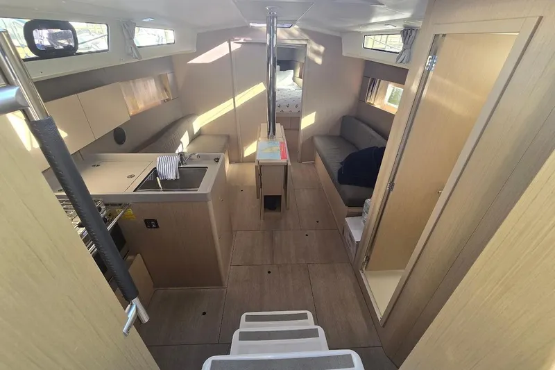 Slide: The Image of Interior of 2023 Beneteau Oceanis 38.1 yacht, featuring modern kitchen and cozy seating area. - 3