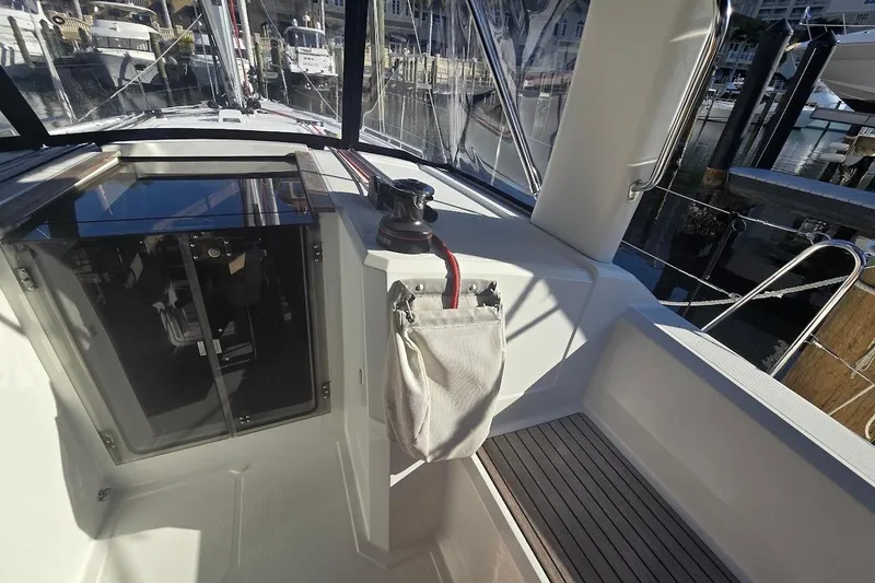 Slide: The Image of Cockpit view of 2023 Beneteau Oceanis 38.1 sailboat, featuring sleek design and marina backdrop. - 30