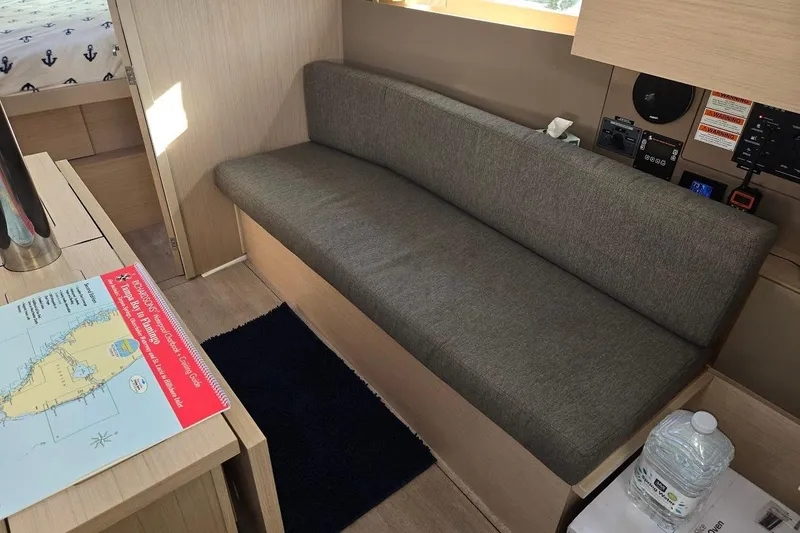 Slide: The Image of Interior of 2023 Beneteau Oceanis 38.1 yacht with gray sofa and navigation map. - 39