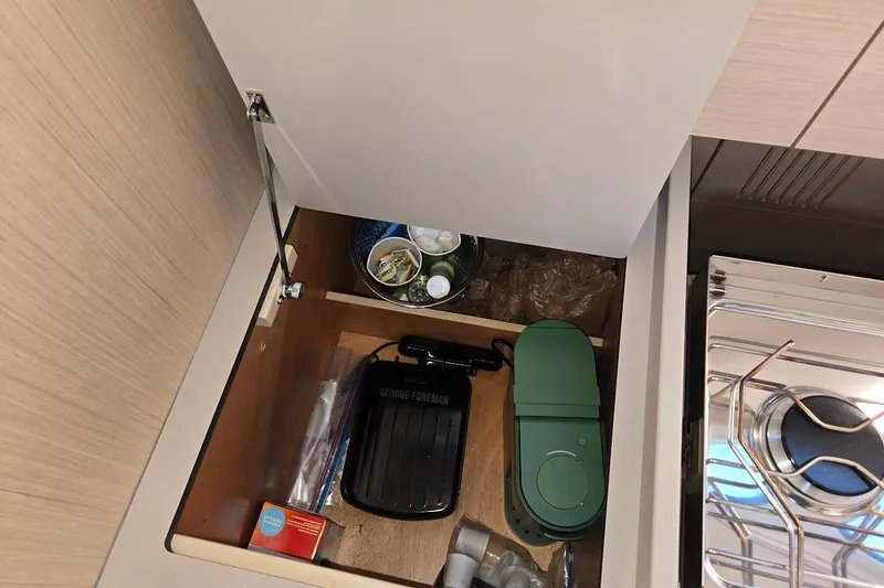 Slide: The Image of Storage compartment in 2023 Beneteau Oceanis 38.1 yacht kitchen with various items. - 49