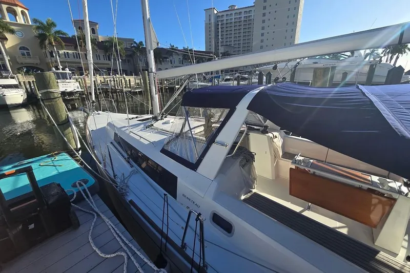 Slide: The Image of 2023 Beneteau Oceanis 38.1 sailboat docked at a marina under clear blue skies. - 65