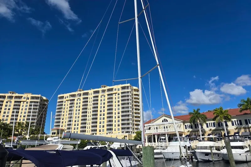 Slide: The Image of 2023 Beneteau Oceanis 38.1 sailboat docked at marina with buildings in background. - 66