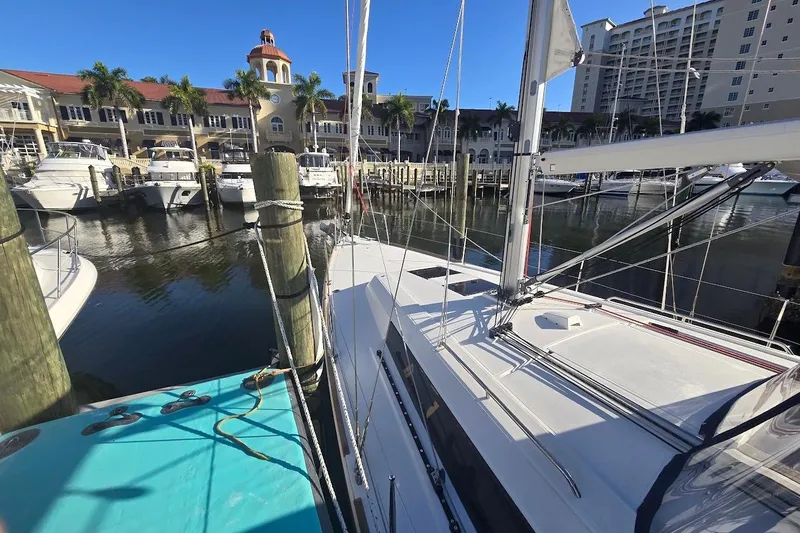 Slide: The Image of 2023 Beneteau Oceanis 38.1 yacht docked at a marina with waterfront buildings. - 68