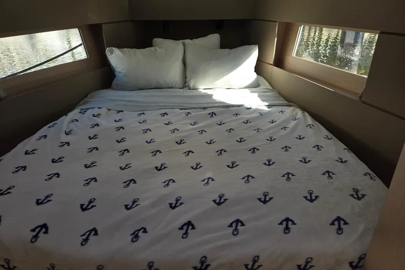 Slide: The Image of Cozy cabin interior of 2023 Beneteau Oceanis 38.1 with anchor-patterned bedding. - 7