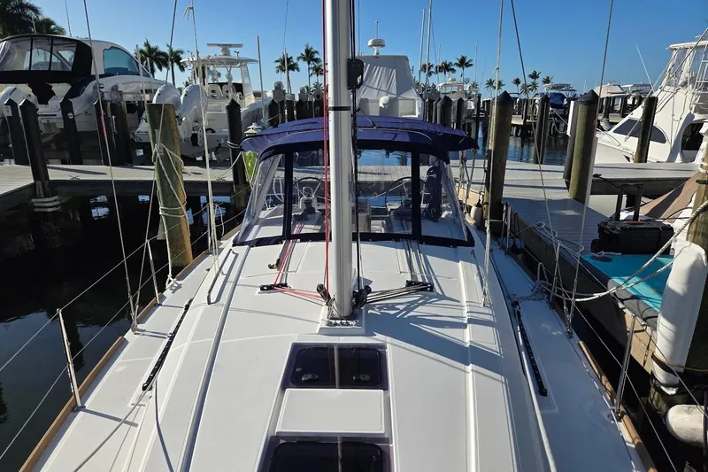 Slide: The Image of 2023 Beneteau Oceanis 38.1 sailboat docked at marina, clear blue sky. - 77