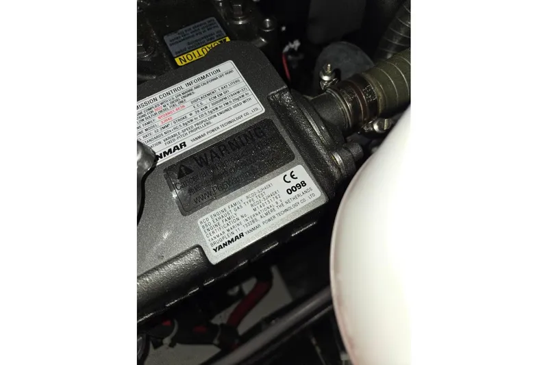 Slide: The Image of Engine compartment of 2023 Beneteau Oceanis 38.1, featuring Yanmar components and warning labels. - 87