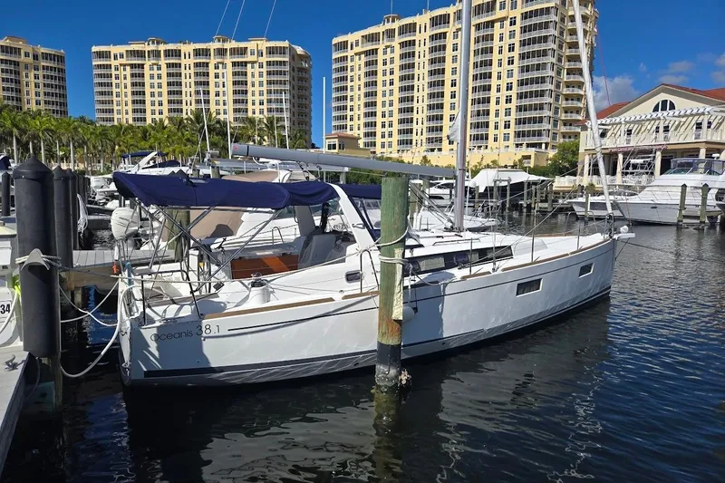 Slide: The Image of 2023 Beneteau Oceanis 38.1 yacht docked at marina with luxury buildings in background. - 89