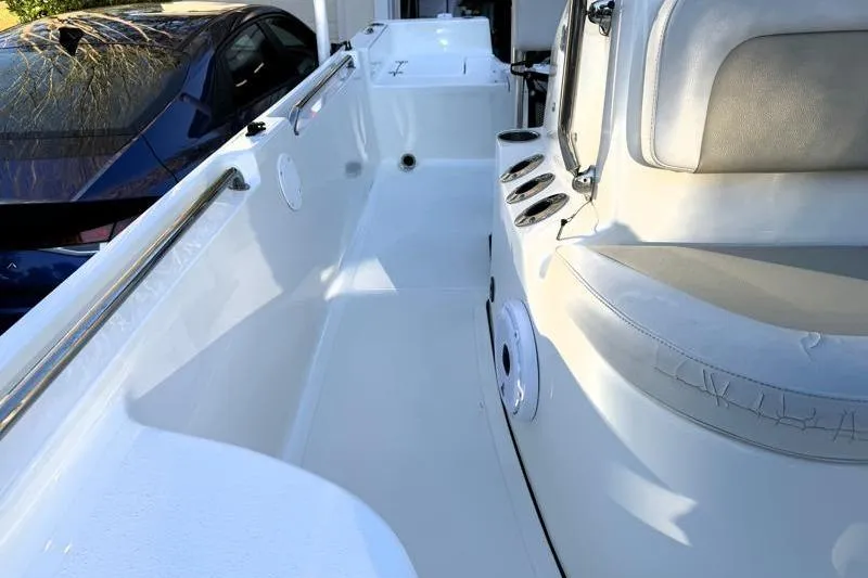 Slide: The Image of 2019 Bulls Bay 2000 boat interior with seating and cup holders, parked beside a car. - 21
