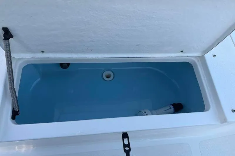 Slide: The Image of Open storage compartment on 2019 Bulls Bay 2000 boat, featuring a blue interior. - 33