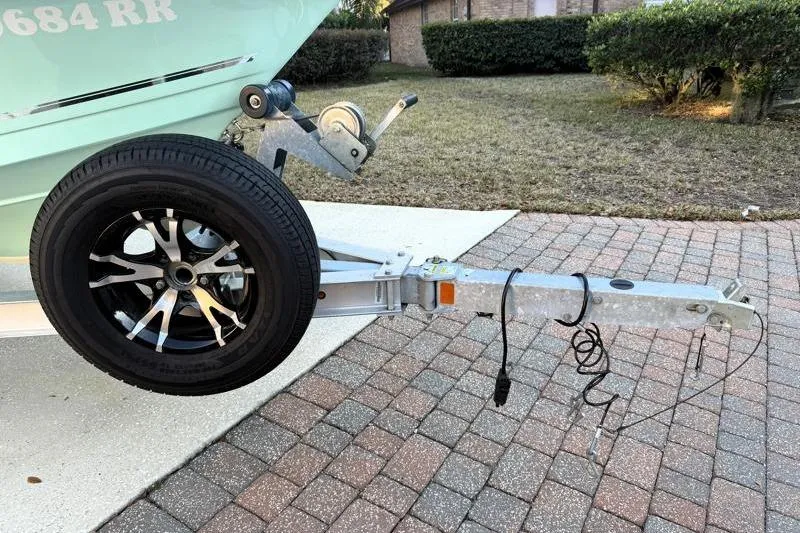 Slide: The Image of Trailer hitch and wheel of a 2019 Bulls Bay 2000 boat on a brick driveway. - 44