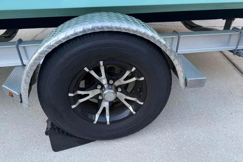 Slide: The Image of 2019 Bulls Bay 2000 trailer wheel with metal fender on concrete surface. - 47
