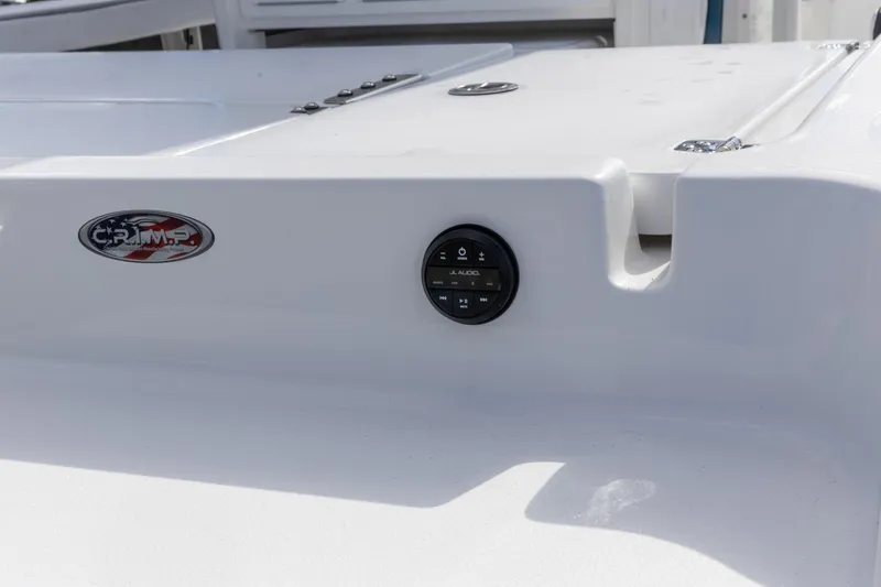 Slide: The Image of 2024 Crevalle 26 HCO boat on trailer, surrounded by other boats, under a clear blue sky. - 13