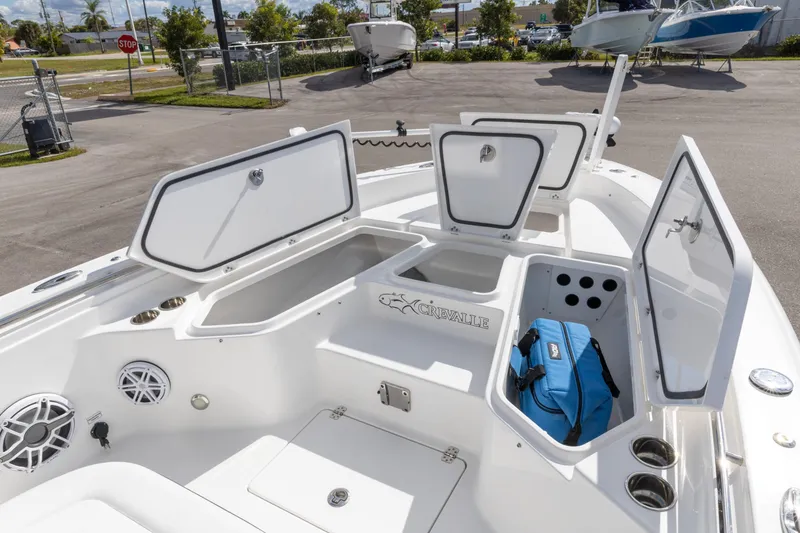 Slide: The Image of 2024 Crevalle 26 HCO boat interior with open storage compartments and blue bag. - 2