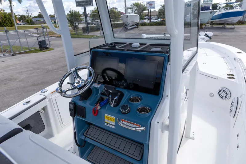 Slide: The Image of 2024 Crevalle 26 HCO boat dashboard with steering wheel and electronic controls. - 4
