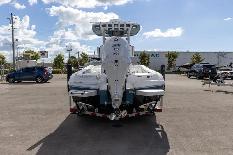 Slide: The Image of 2024 Crevalle 26 HCO boat with powerful outboard motor, parked outdoors under a blue sky. - 6