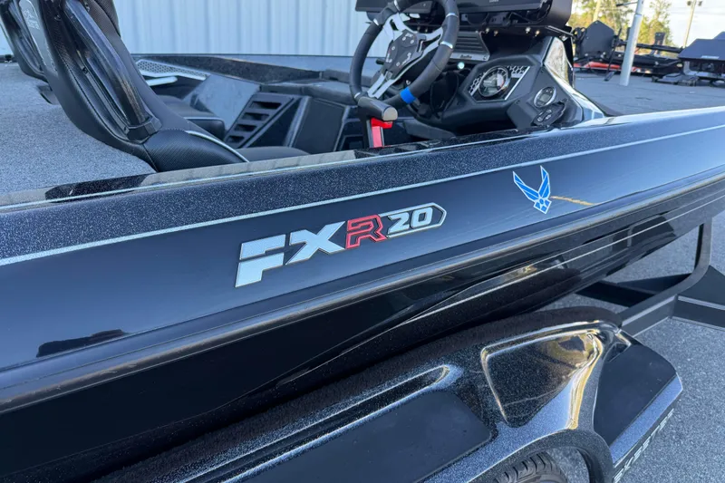 Slide: The Image of 2023 Skeeter FXR20 Select boat, sleek black design with logo and steering wheel visible. - 2